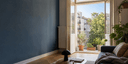 A bright Berlin apartment with an open balcony overlooking a leafy neighborhood